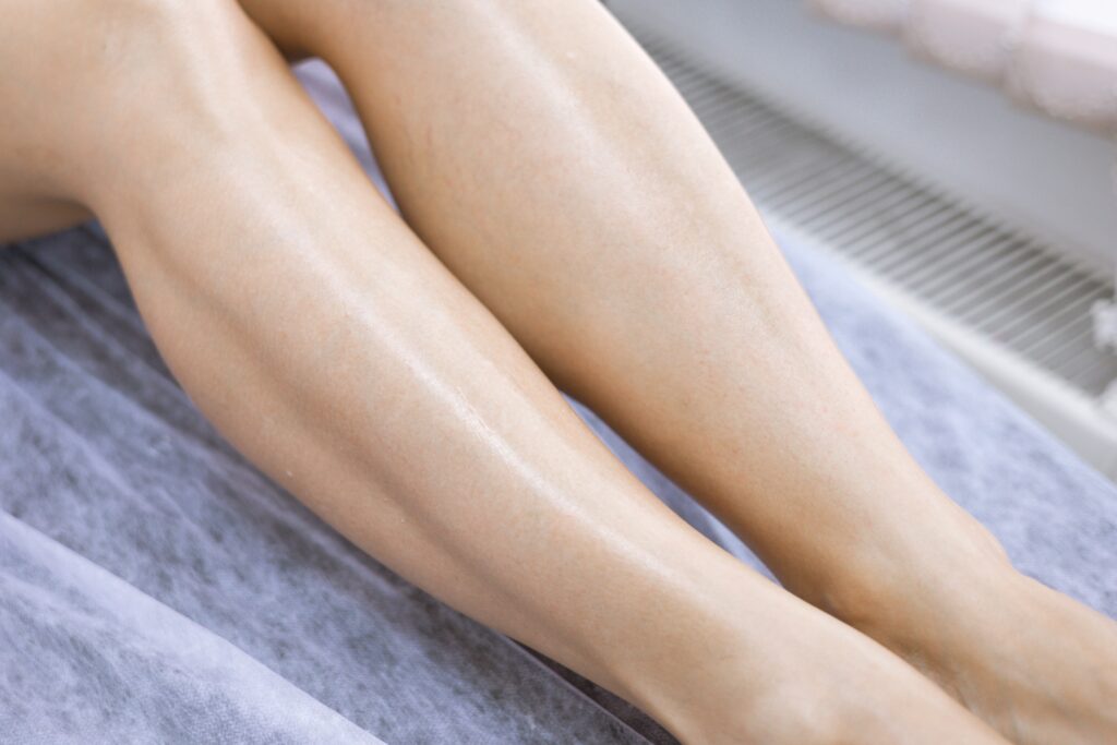 female legs after hair removal with sugaring procedure in beauty salon