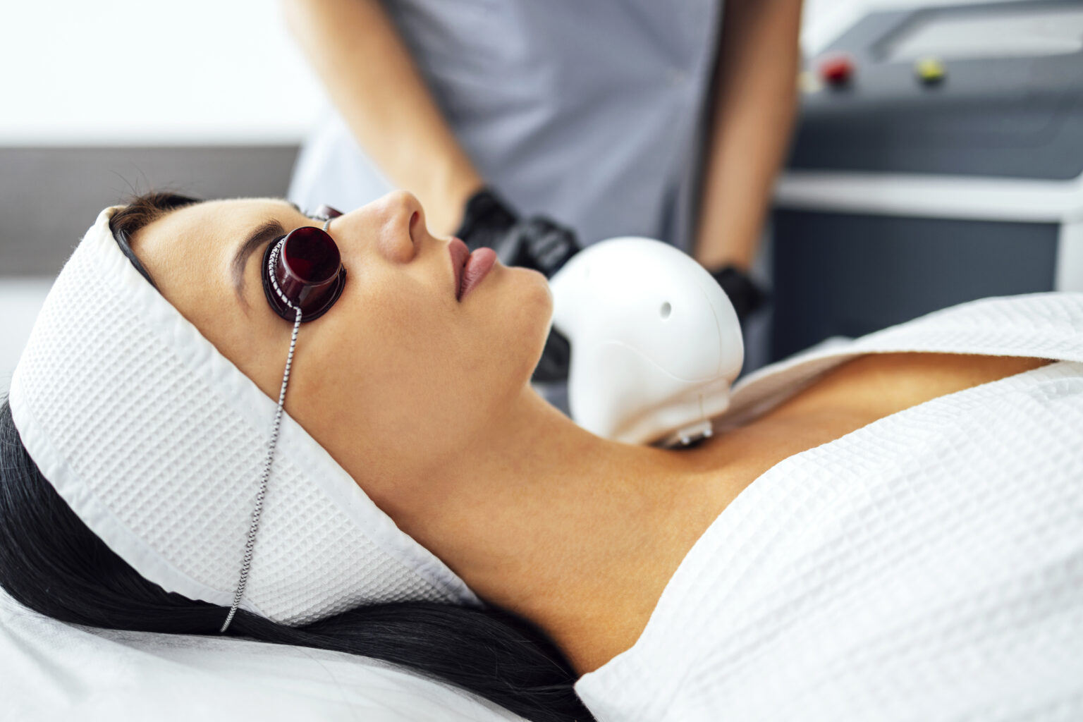 Portrait of relaxed young female client getting SMAS ultrasound face lifting massage