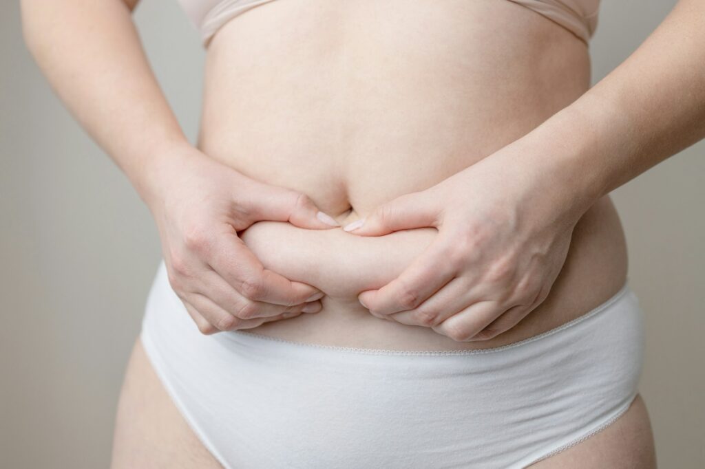 Fat woman hand holding fat belly